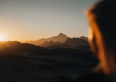 the sun is setting over a mountain range